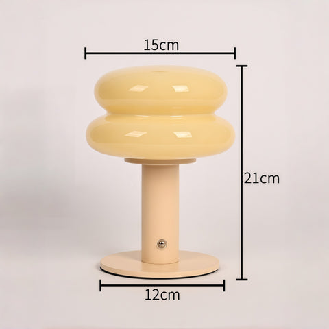 cream-style glass egg-tart lamp glowing with soft warm light from Gallery of Use